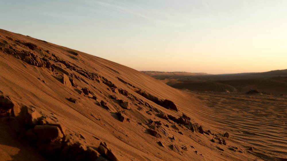 sable brun sous ciel blanc pendant la journée