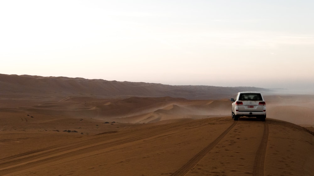 Weißer SUV auf braunem Sand