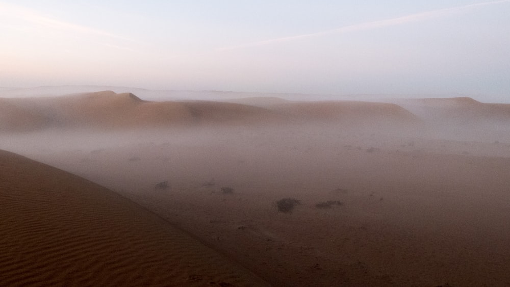 areia marrom sob o céu azul durante o dia