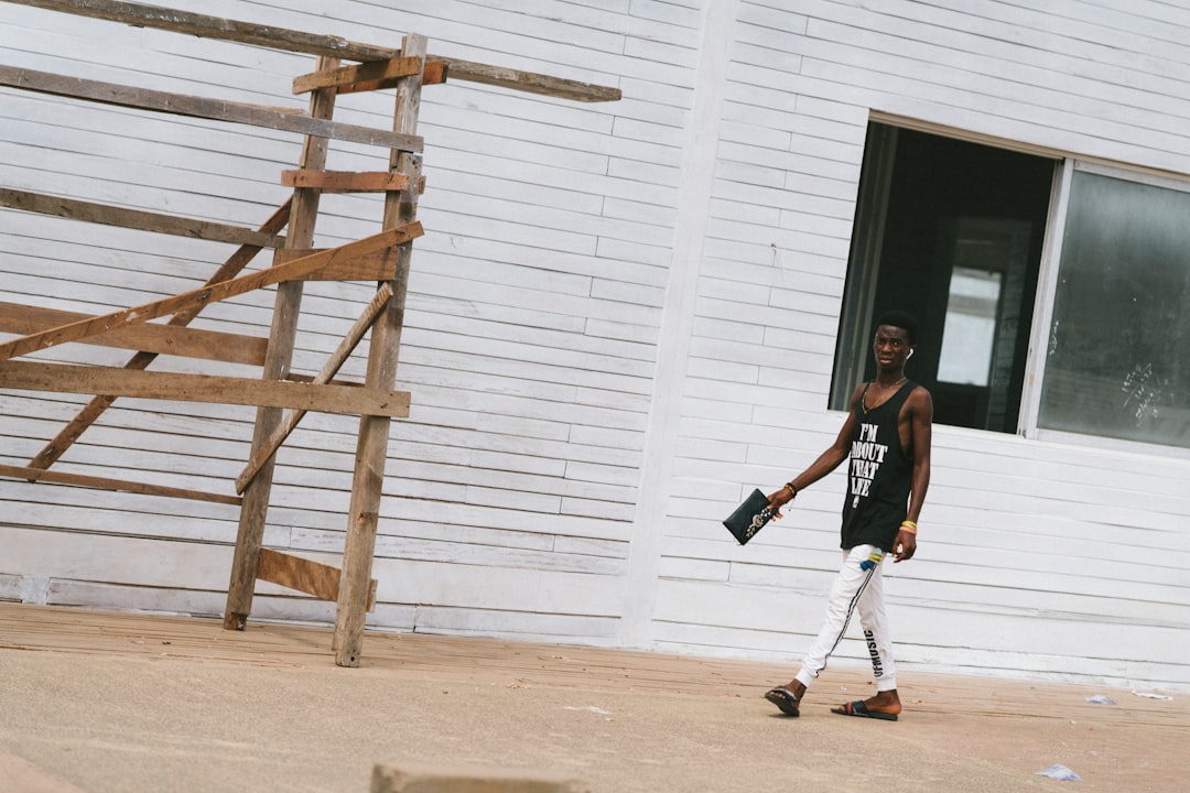 man in black tank top and black shorts holding white stick