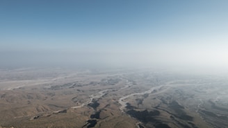 Aerial view of vast desert land parcels with clear boundary markings under a golden sunset.