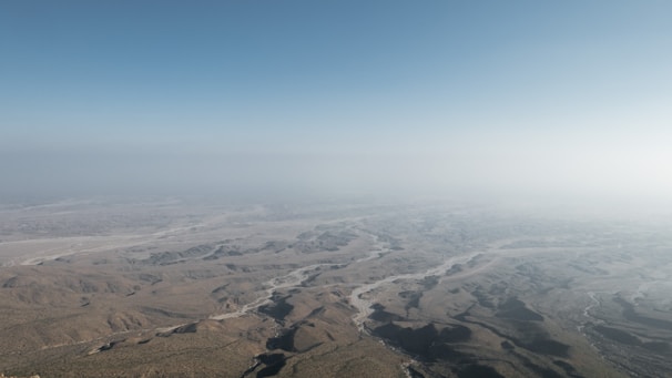 Aerial view of vast desert land parcels with clear boundary markings under a golden sunset.