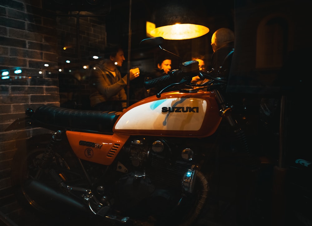 motocicleta laranja e preta estacionada ao lado da motocicleta preta