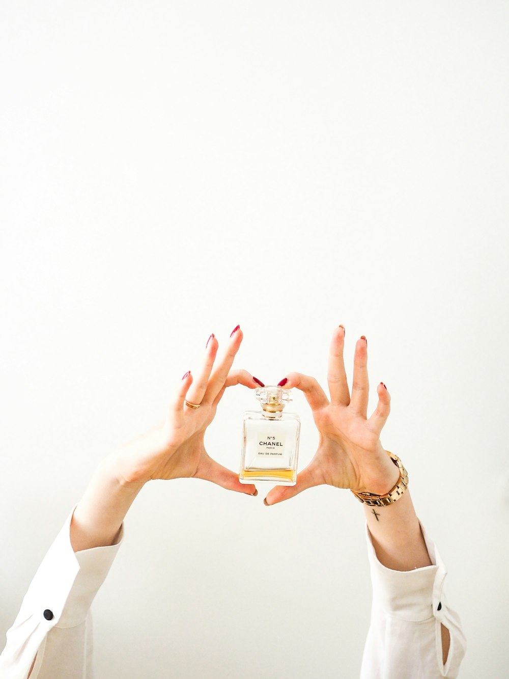 person in white long sleeve shirt holding white plastic bottle