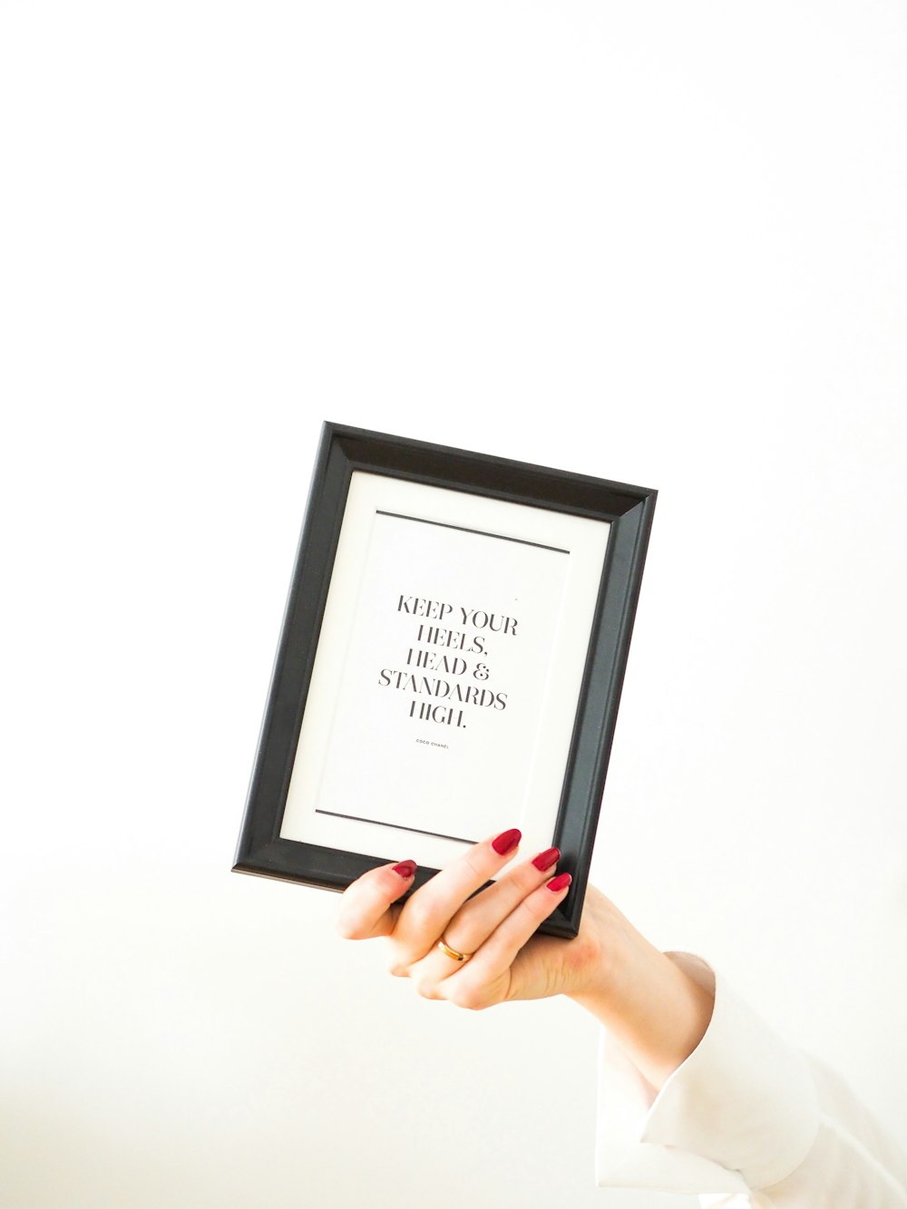 person holding black framed white arabic text