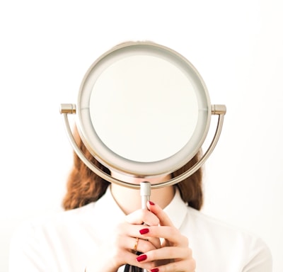 woman in white long sleeve shirt holding magnifying glass