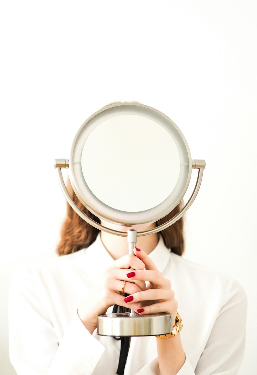 woman in white long sleeve shirt holding magnifying glass