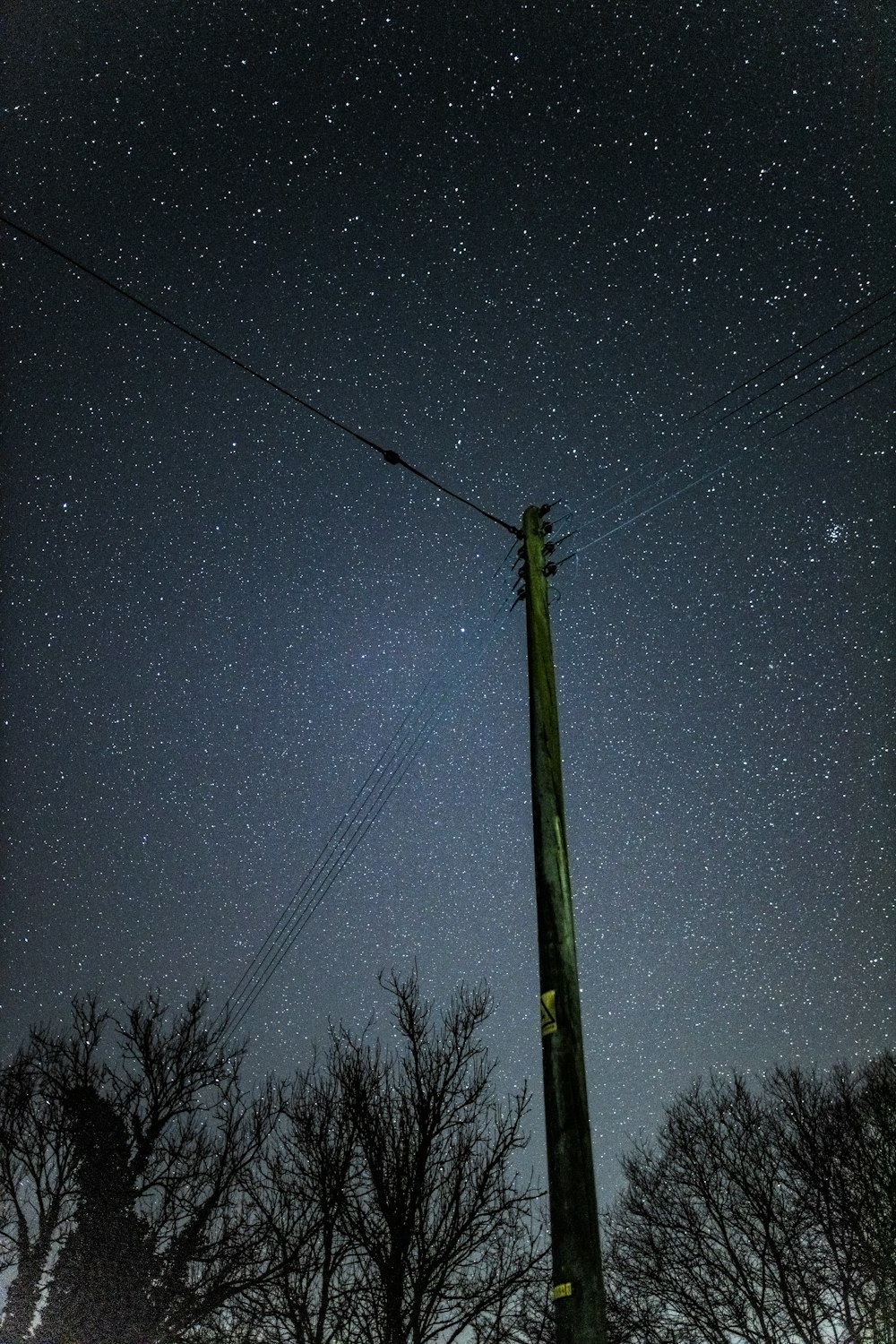 black electric post under blue sky during night time