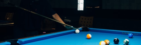 man in black jacket playing billiard