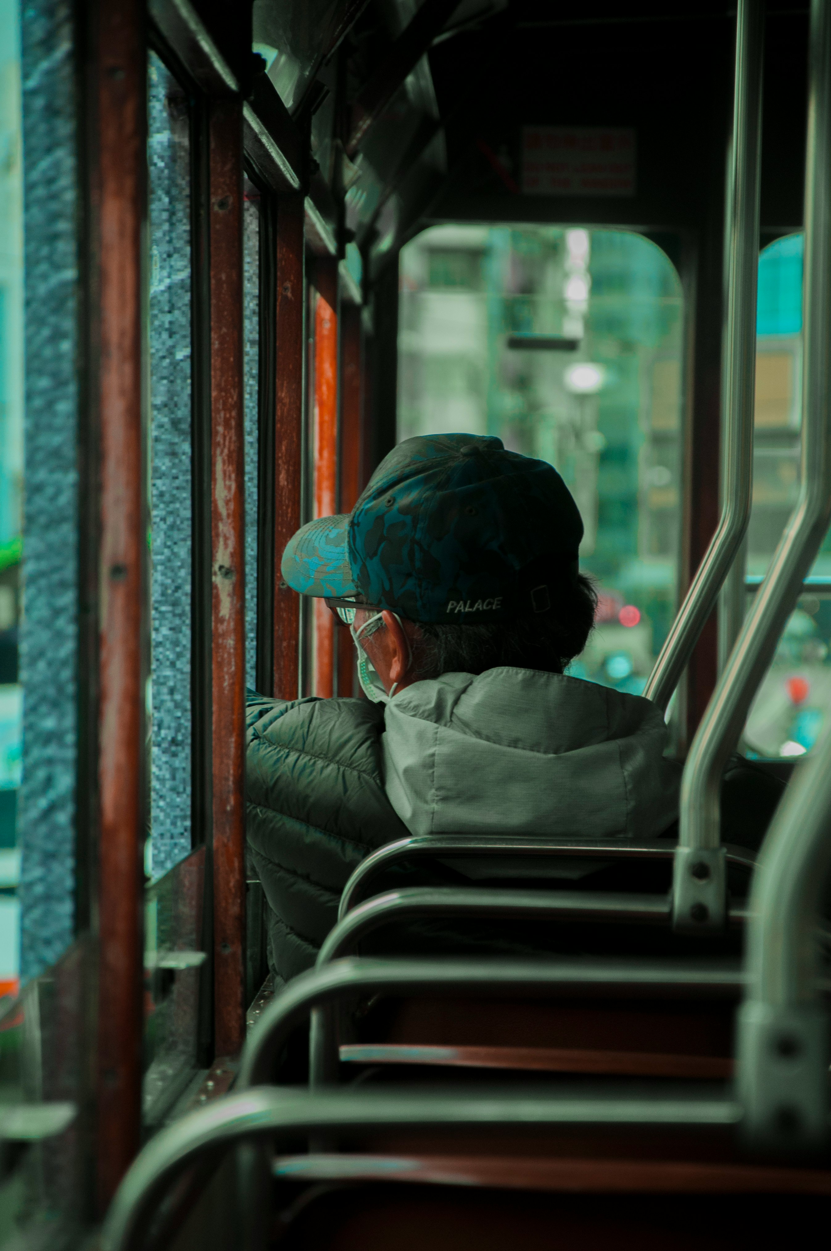 man in gray hoodie sitting on train seat