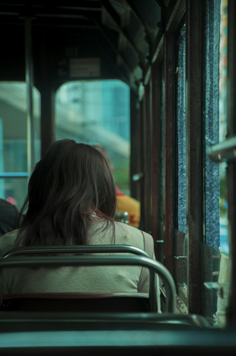 Frau in brauner Jacke sitzt im Zug