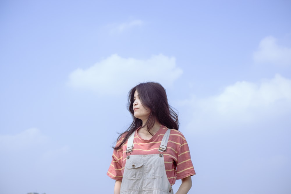 woman in orange and white stripe shirt and blue denim shorts