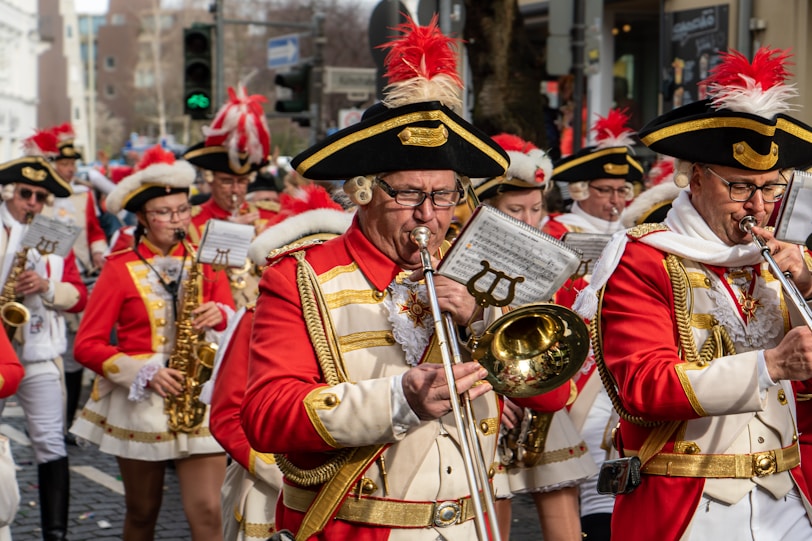 people in red and white traditional dress playing musical instruments during a parade