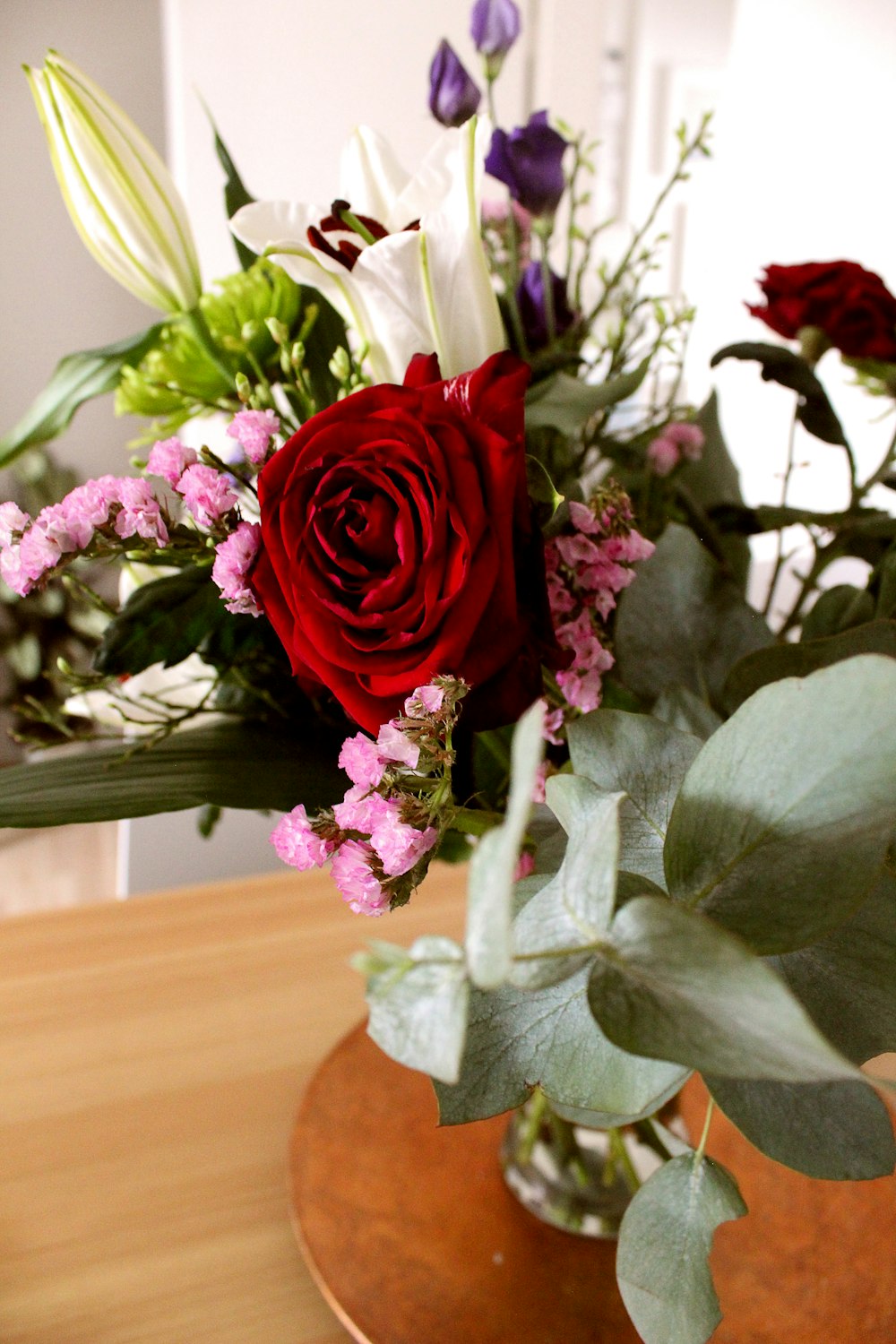 red rose in white vase