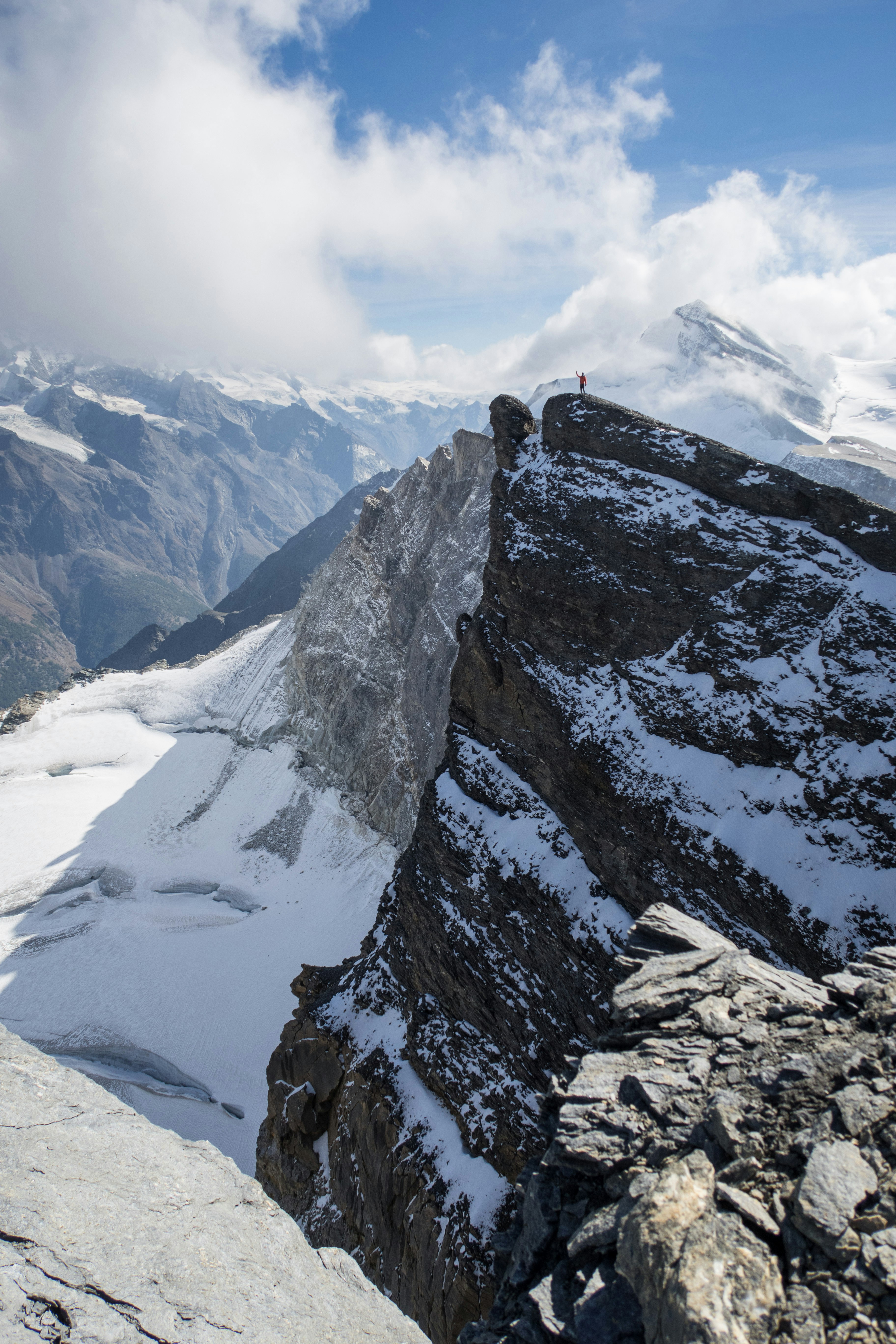 person in black jacket standing on snow covered mountain during daytime