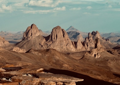 brown rocky mountain under white clouds during daytime