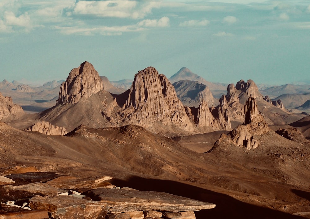 Montaña rocosa marrón bajo nubes blancas durante el día