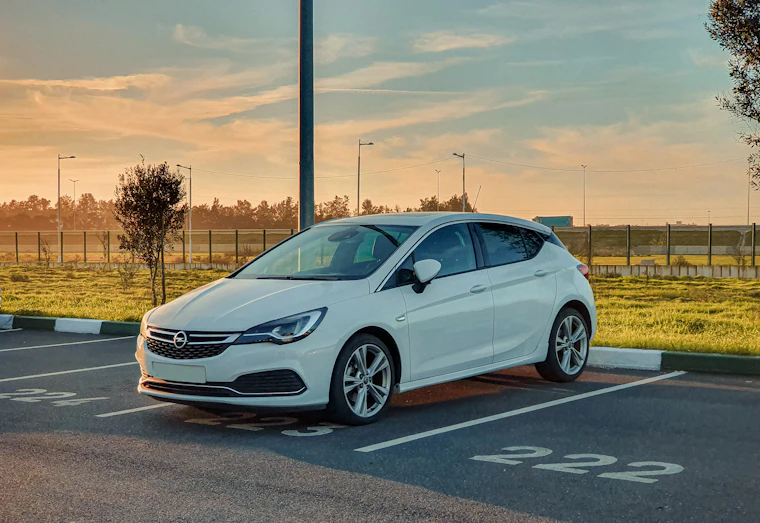 Beyaz Opel Astra, çizgili park yerinde