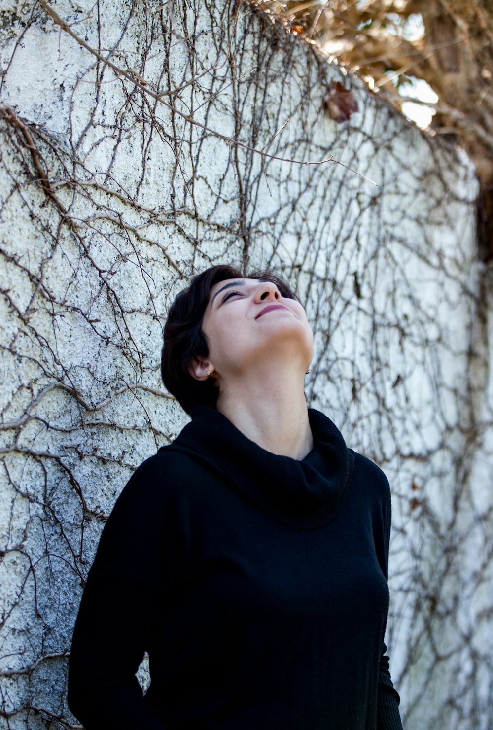 woman in black turtleneck shirt standing near bare tree during daytime