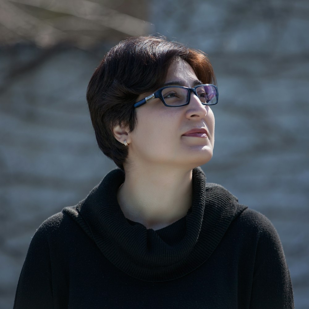 woman in black turtleneck sweater wearing black framed eyeglasses