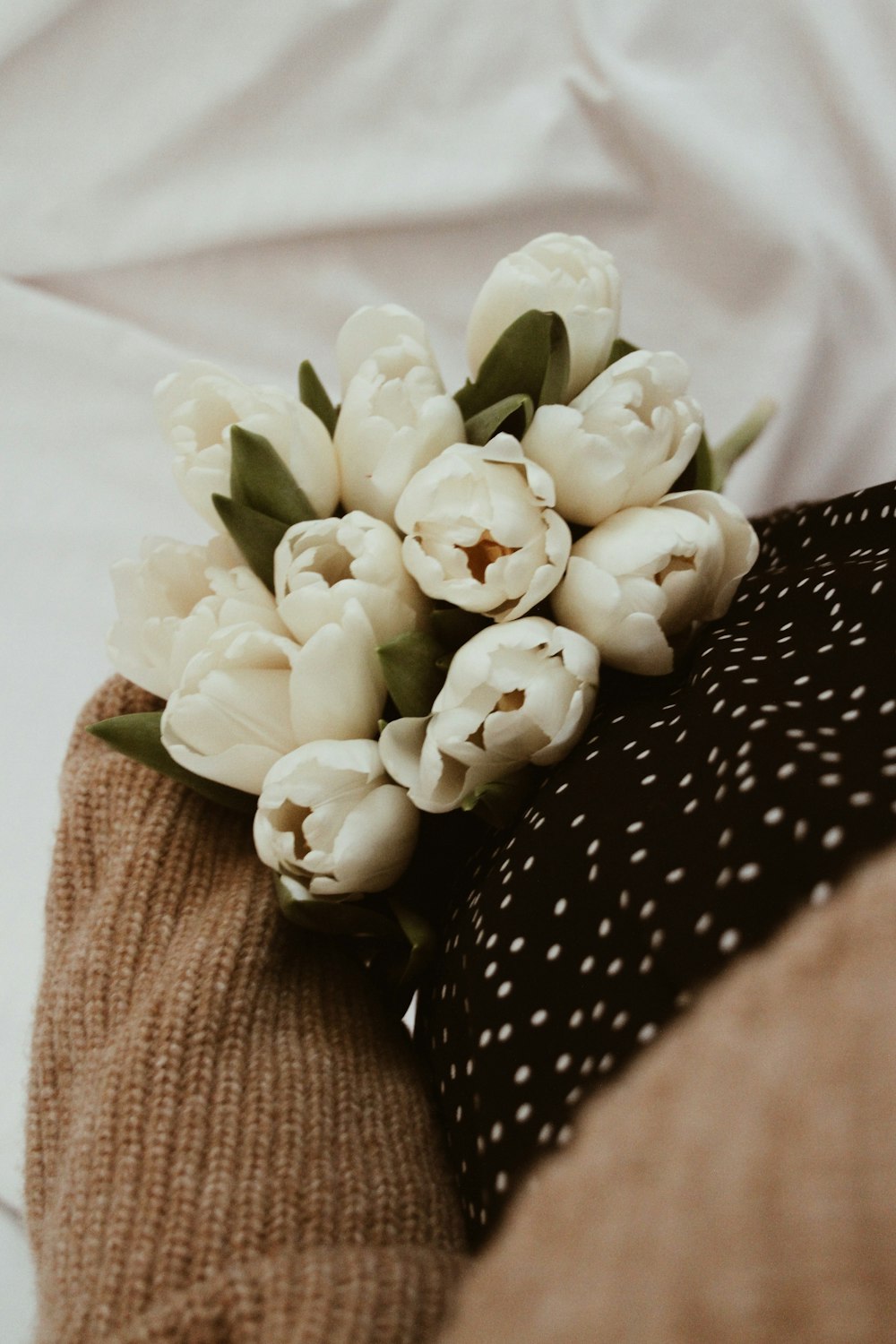 white flowers on black and white polka dot textile