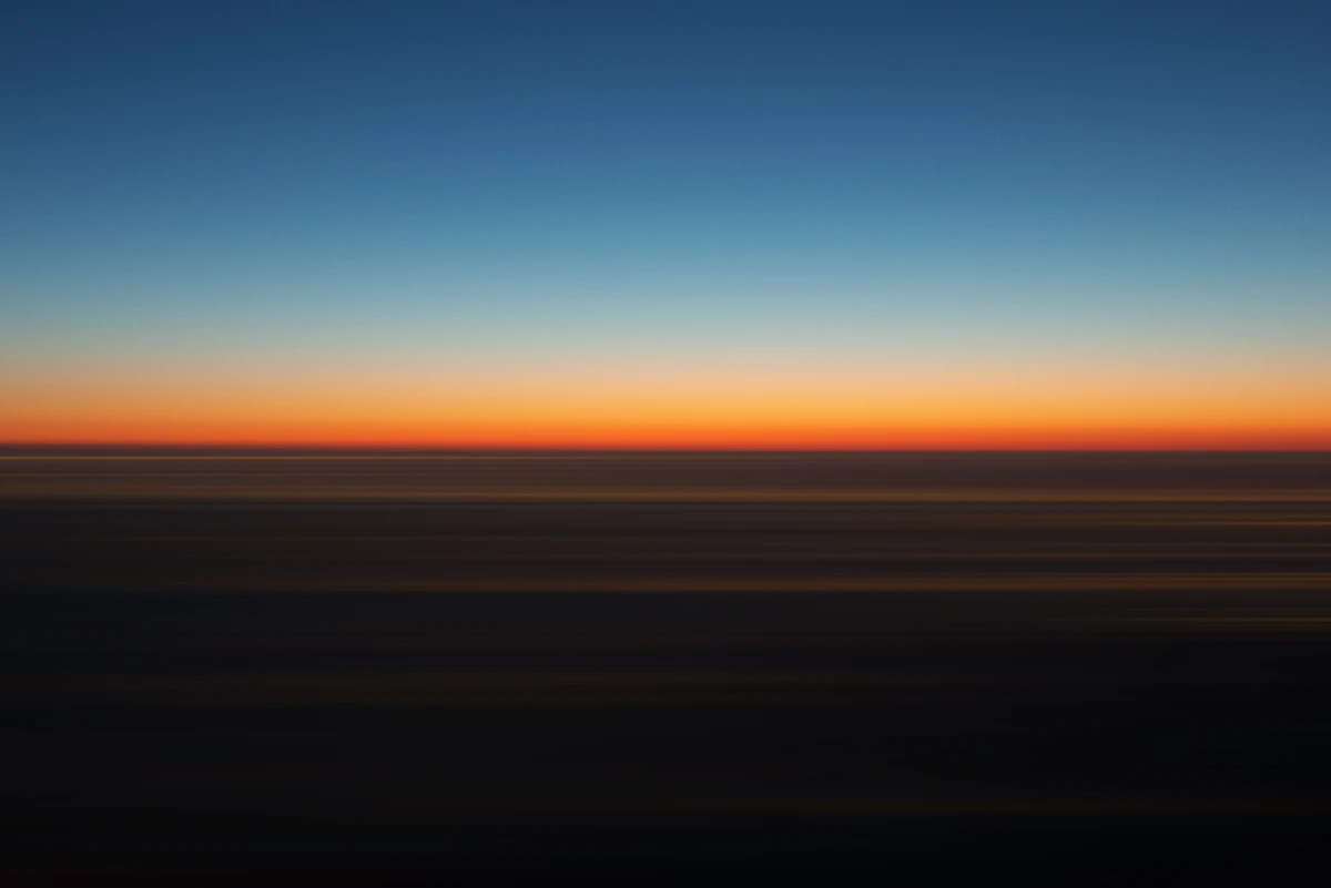 Ciel dégradé bleu et orange à l'horizon au lever du jour