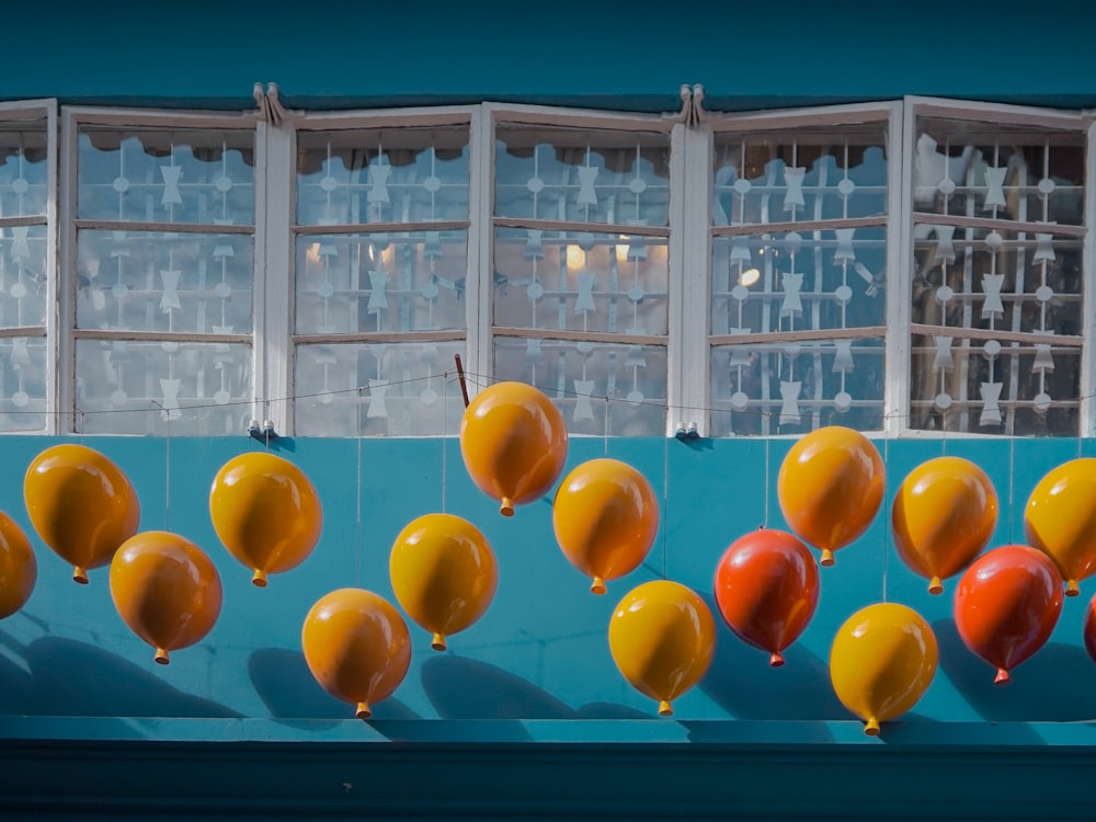 yellow red and blue balloons on white metal frame glass window