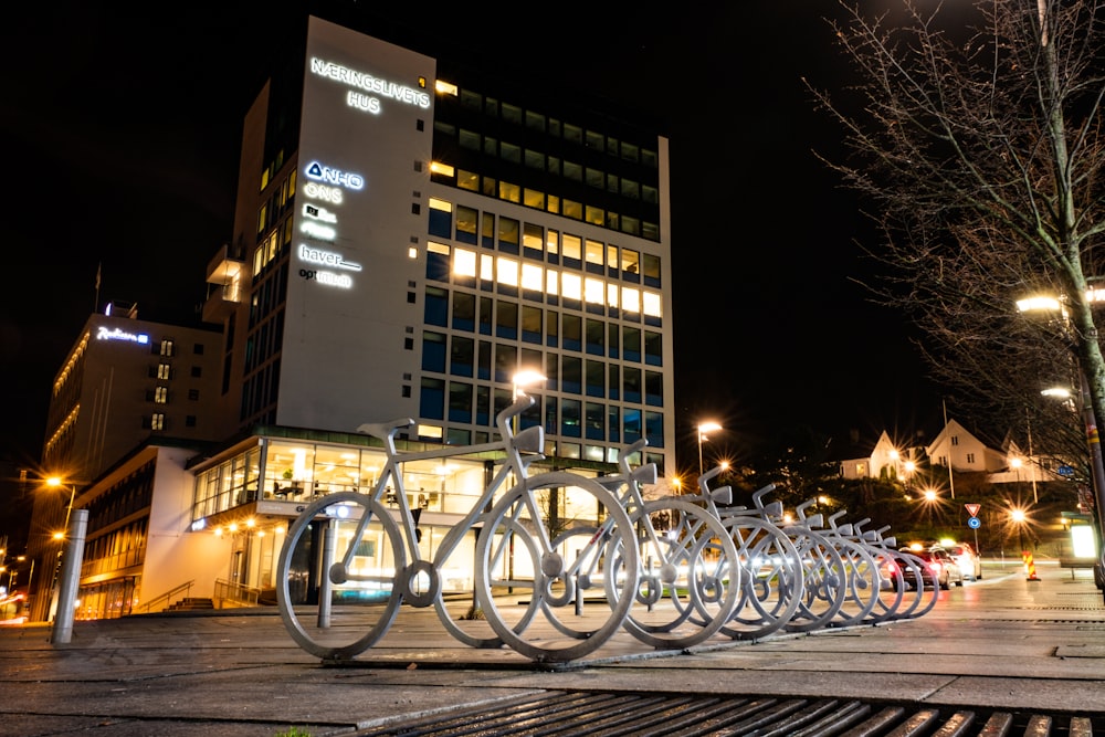 bicycles parked on a parking lot near a building during night time