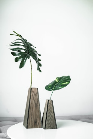 Close-up of a chic, minimalist vase with fresh greenery on a wooden side table.