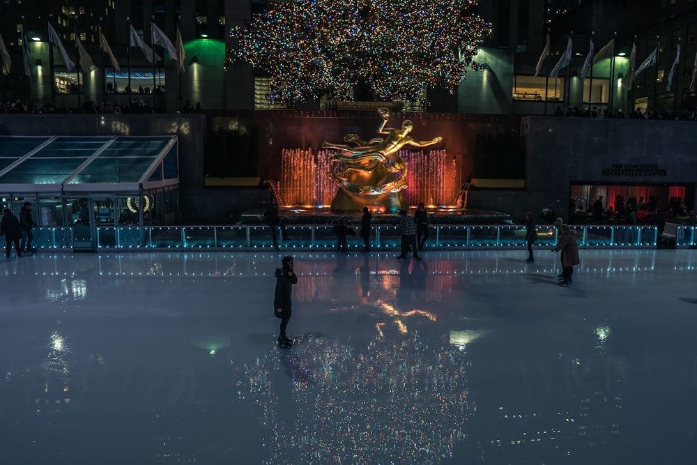 people swimming in pool during nighttime