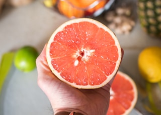 person holding sliced orange fruit