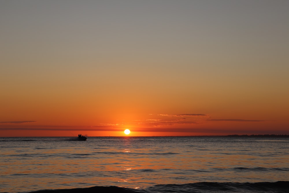 silhouette of person on sea during sunset