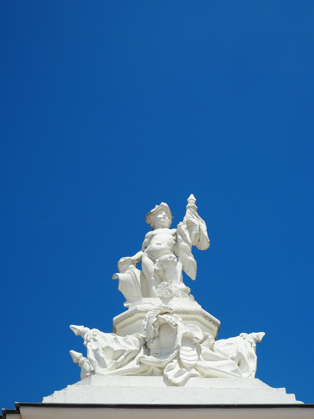 Estatua de hormigón blanco bajo el cielo azul durante el día