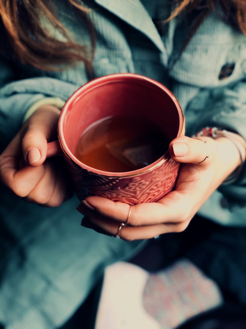 person holding brown ceramic mug