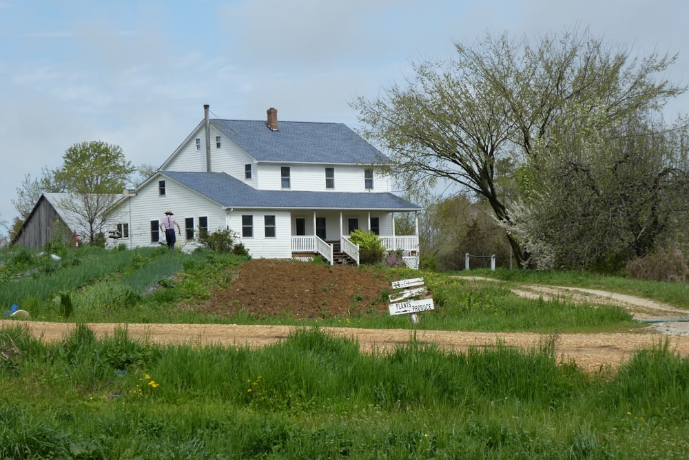 white and brown wooden house near green grass field during daytime