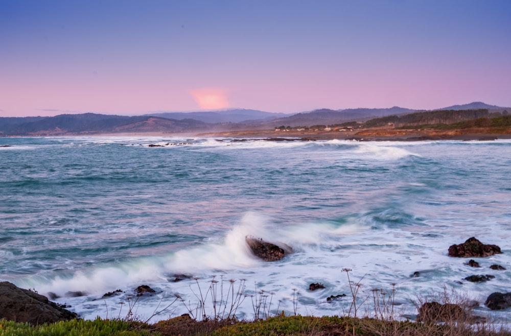 ocean waves crashing on shore during daytime