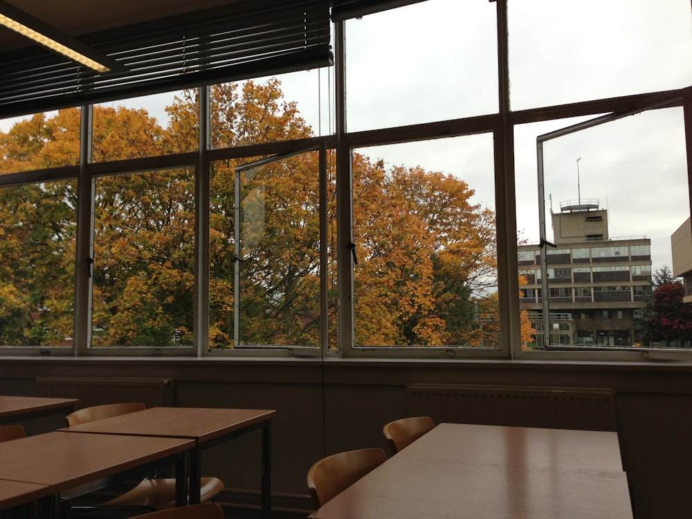 brown wooden table near glass window