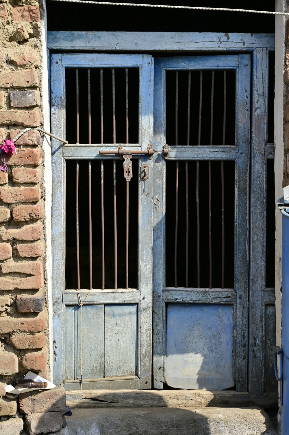 blue wooden door with red flower