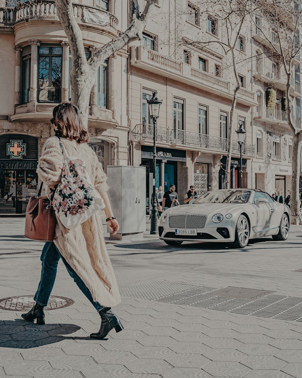 woman in white and red floral long sleeve dress standing on sidewalk during daytime