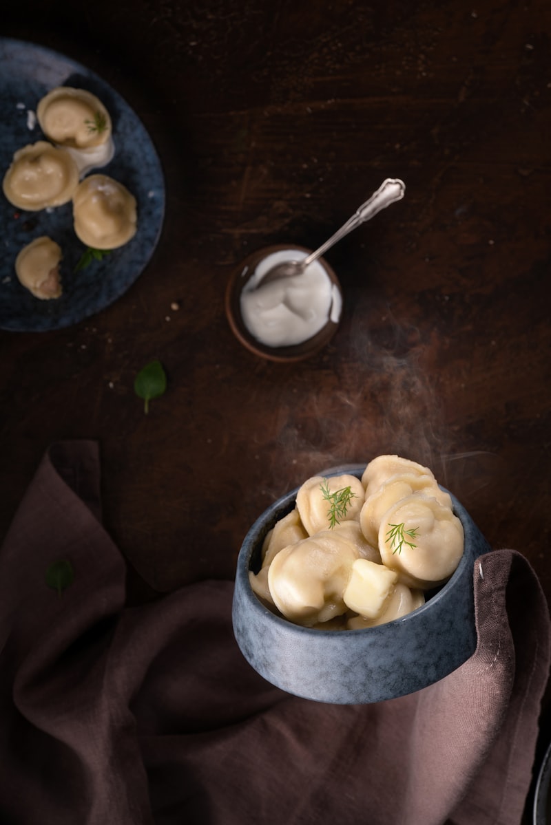 A rustic bowl of soft potato dumplings in a creamy sauce, garnished with fresh dill