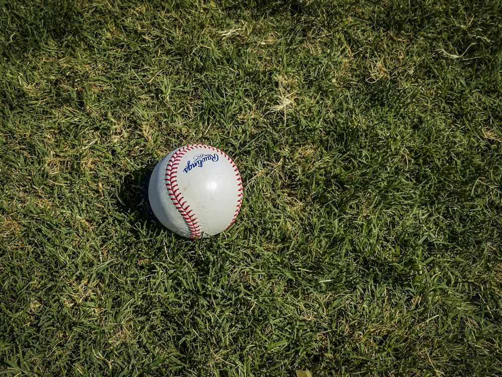 Baseball bianco e rosso su erba verde