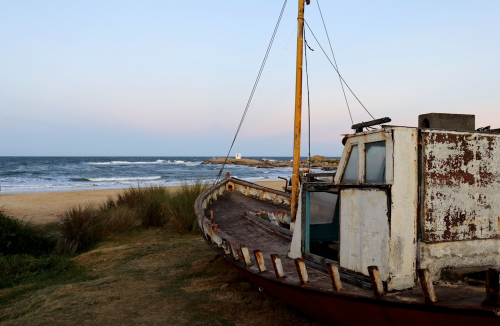 brown and white boat on seashore during daytime