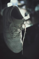 Sneaker with repaired sole and fresh white laces in elegant lighting.