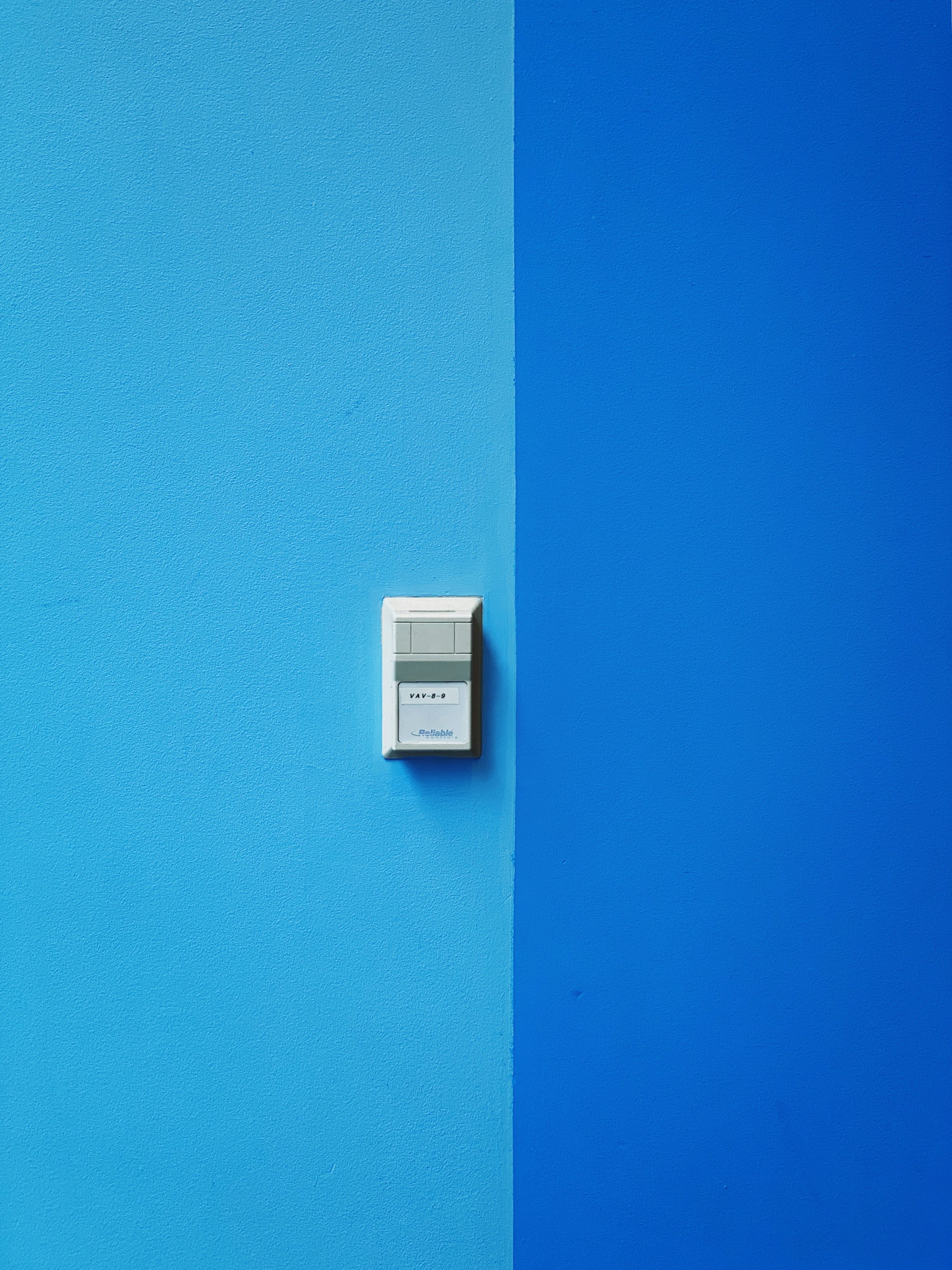 white wall mounted device on blue wall
