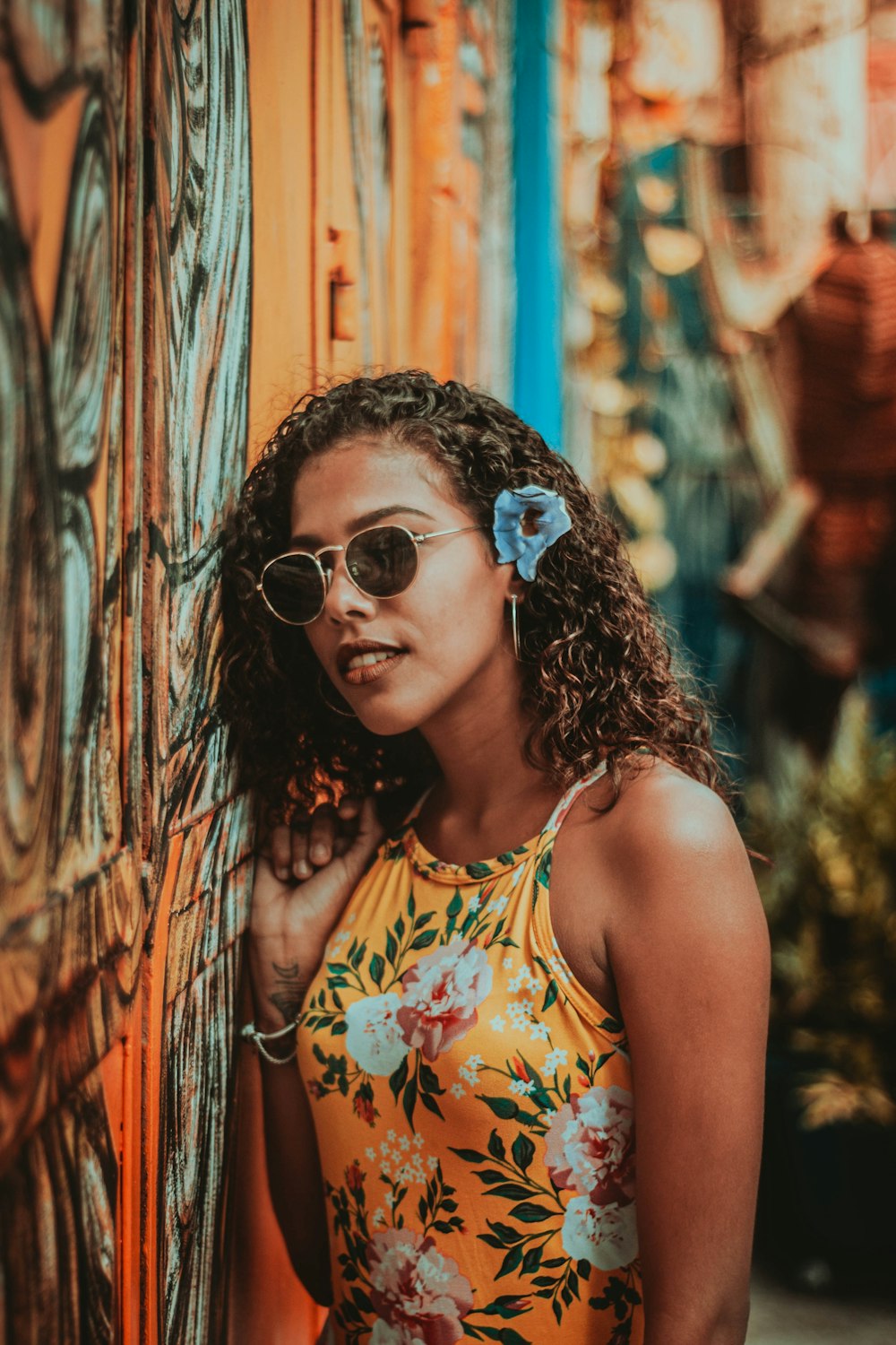 woman in yellow and white floral tank top wearing sunglasses