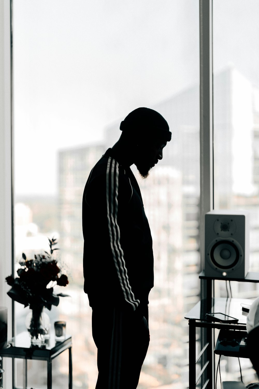 man in black jacket standing near window