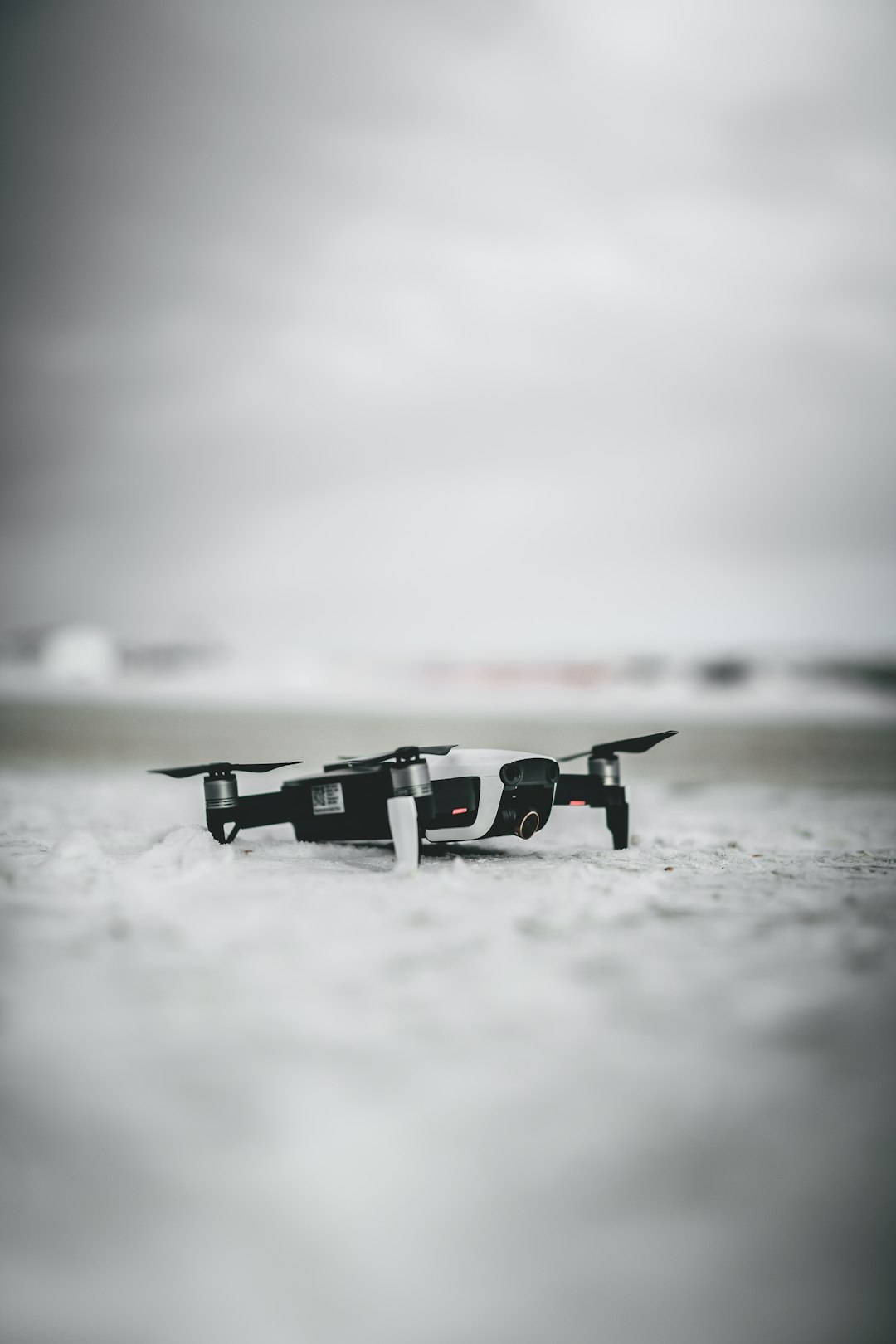 black and white drone flying over the sea