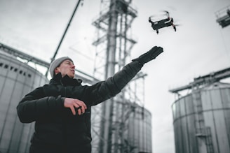 Technician using drone for pest control inspection in an industrial area