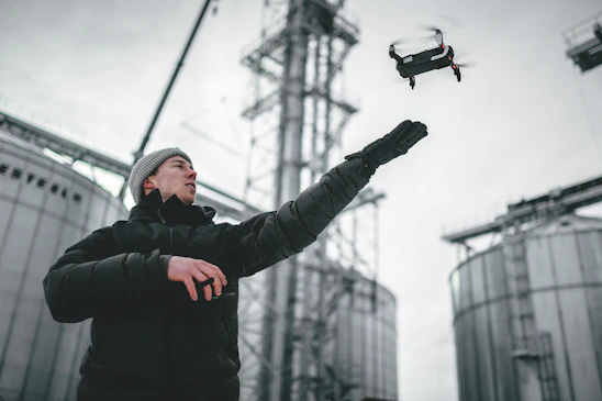 A confident engineer operating a drone over a rugged mining site, illustrating advanced technology in action.