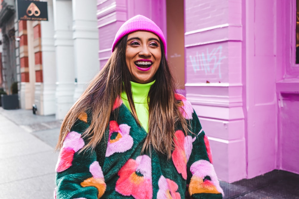 Frau in weißem, blauem und rotem Pullover mit rosa Strickmütze